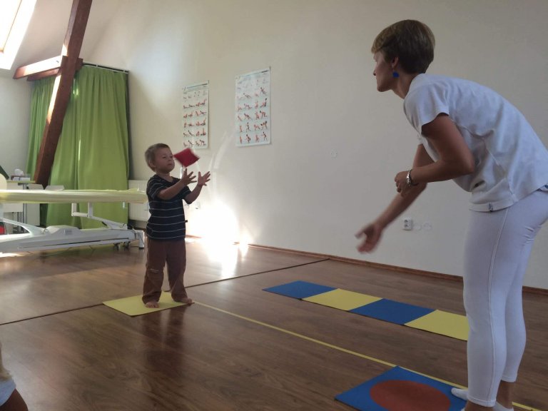Terapeutka vyšetřuje obratnost dítěte v sále